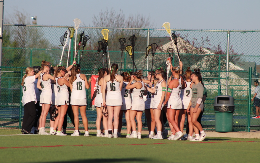 girls huddled with rackets raised